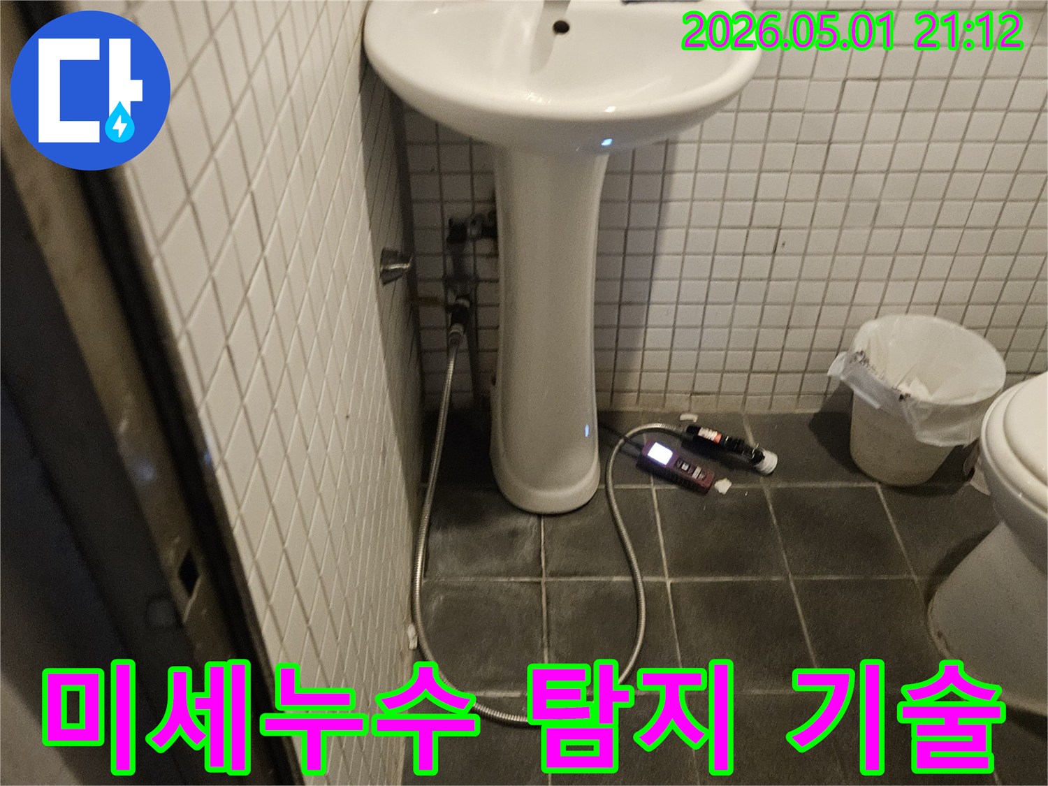 욕실에서 육안으로 확인하기 어려운 미세한 누수를 찾아내기 위해-첨단 탐지 장비를 활용하는 전문가의 모습입니다.