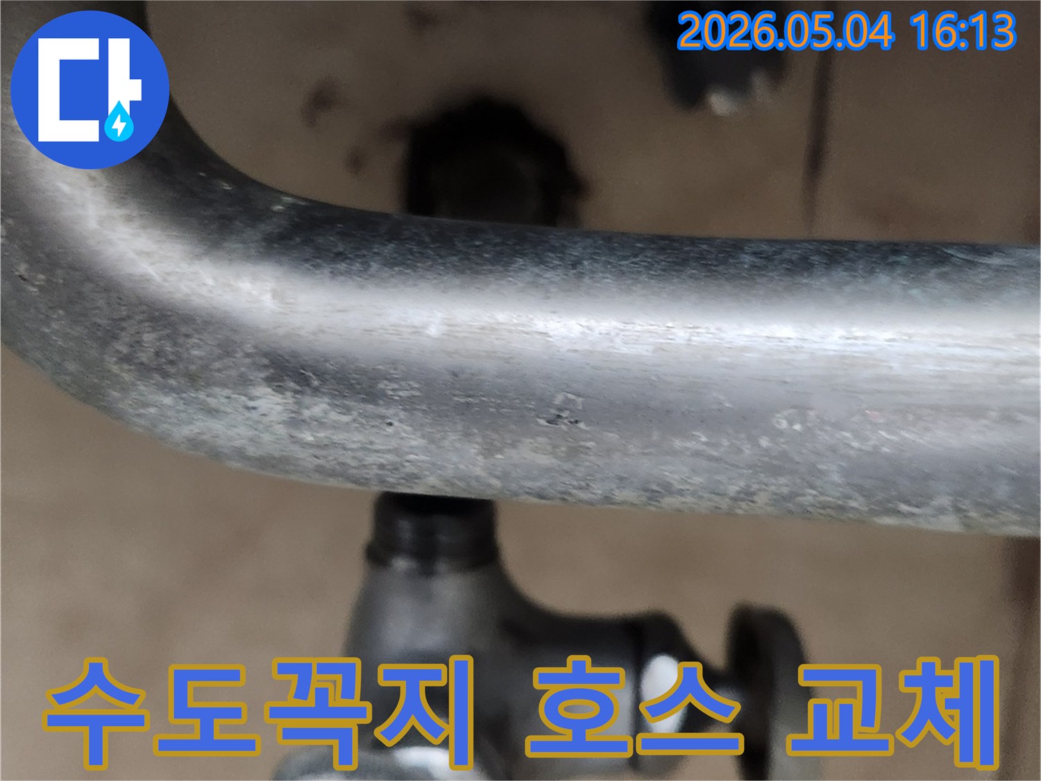 냉수 수도꼭지 아래-고압호스 연결부의-불안정한 상태를 보여주며-교체 작업을 진행하는 모습입니다.