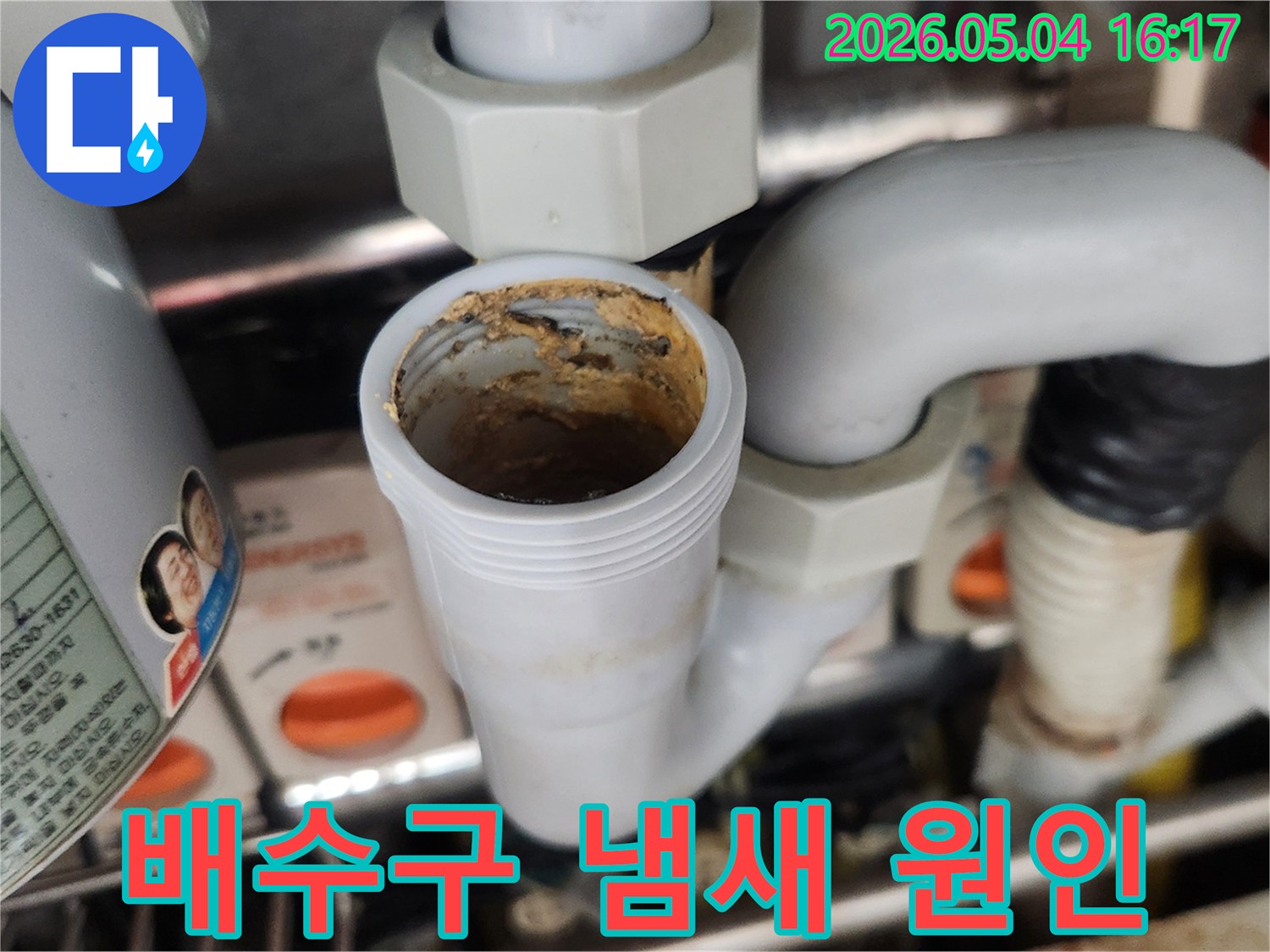 배수구 S-트랩에-쌓인 부패한 이물질이-심각한 악취를-유발하는 모습을-보여주며-전문적인 청소의-필요성을-설명합니다