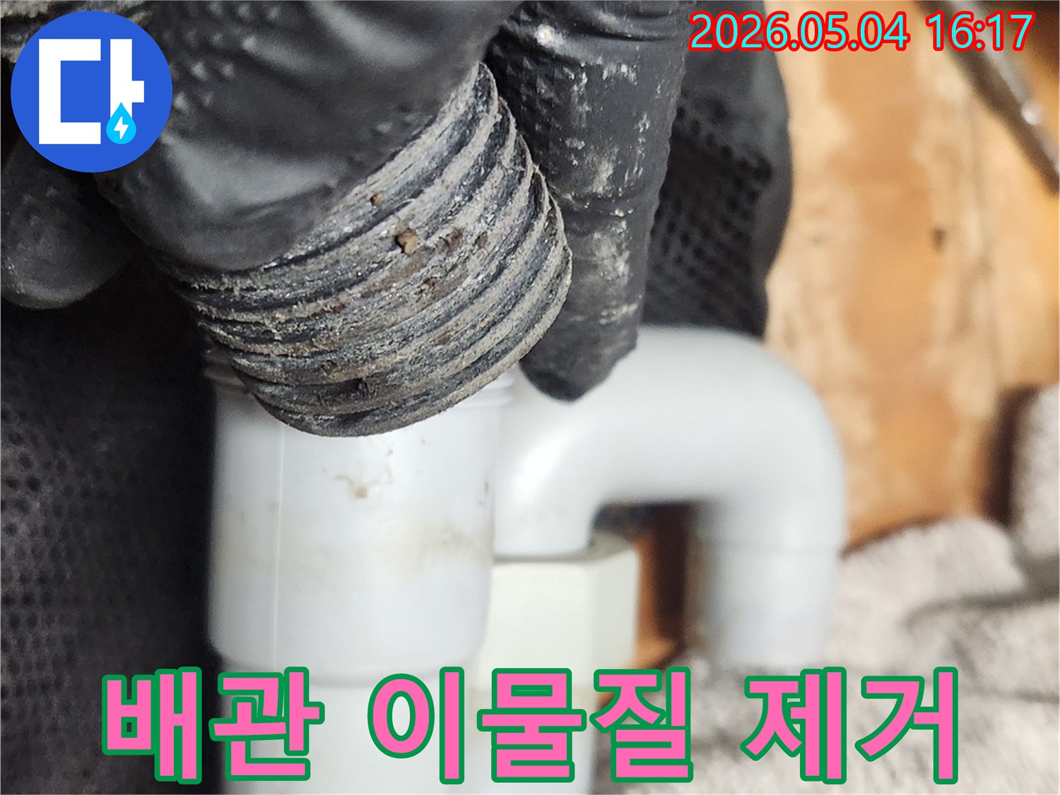 숙련된 엔지니어가-싱크대 배수관의-오염된 S트랩을-분리하여-이물질을 제거하는 사진입니다