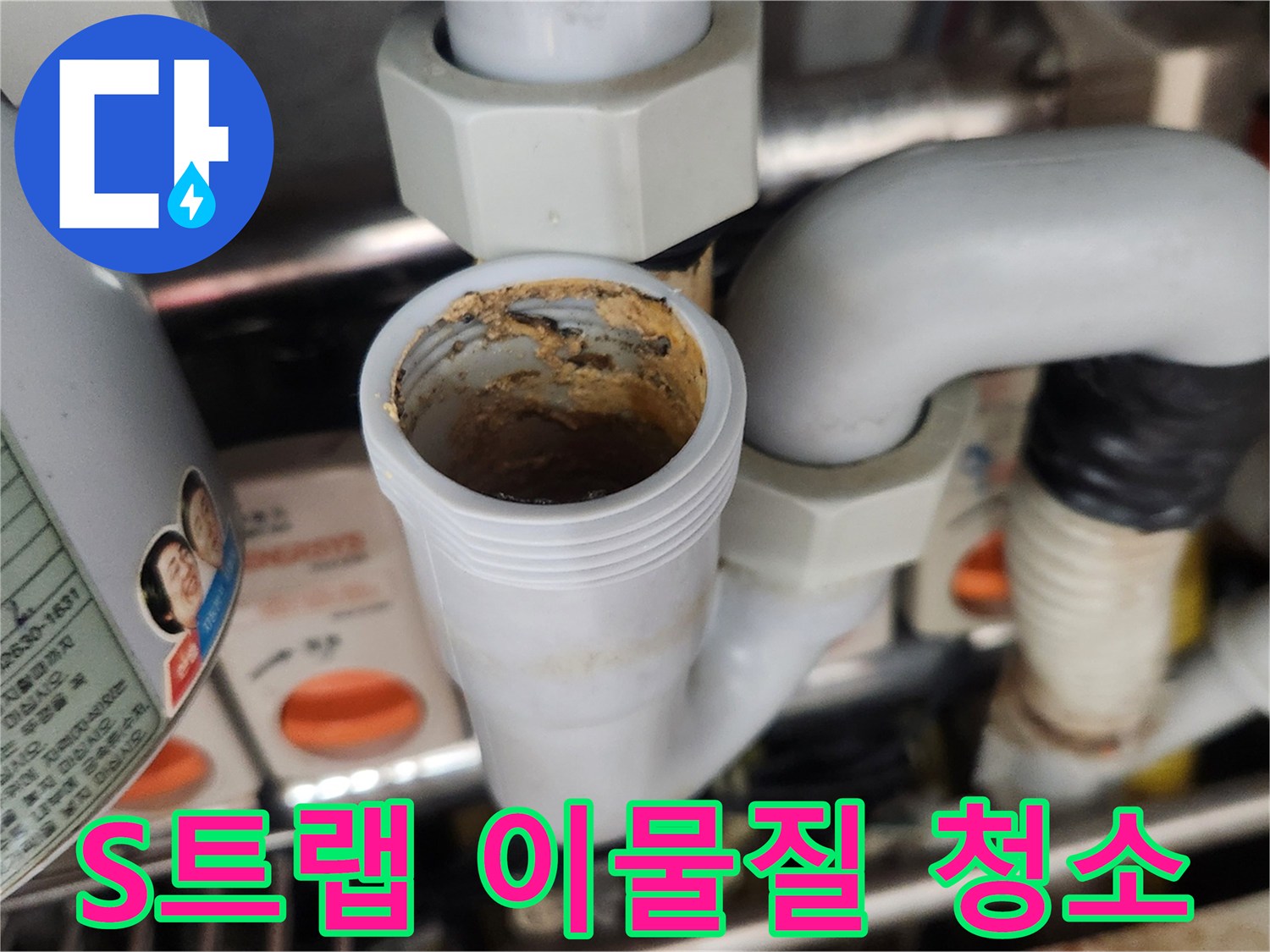 이 이미지는 싱크대 S-트랩 내부에 끈적하게 엉겨 붙은-이물질과 슬러지가 배수 흐름을 방해하는 심각한 오염 상태를-보여주는 것으로 전문적인 청소가 필요합니다