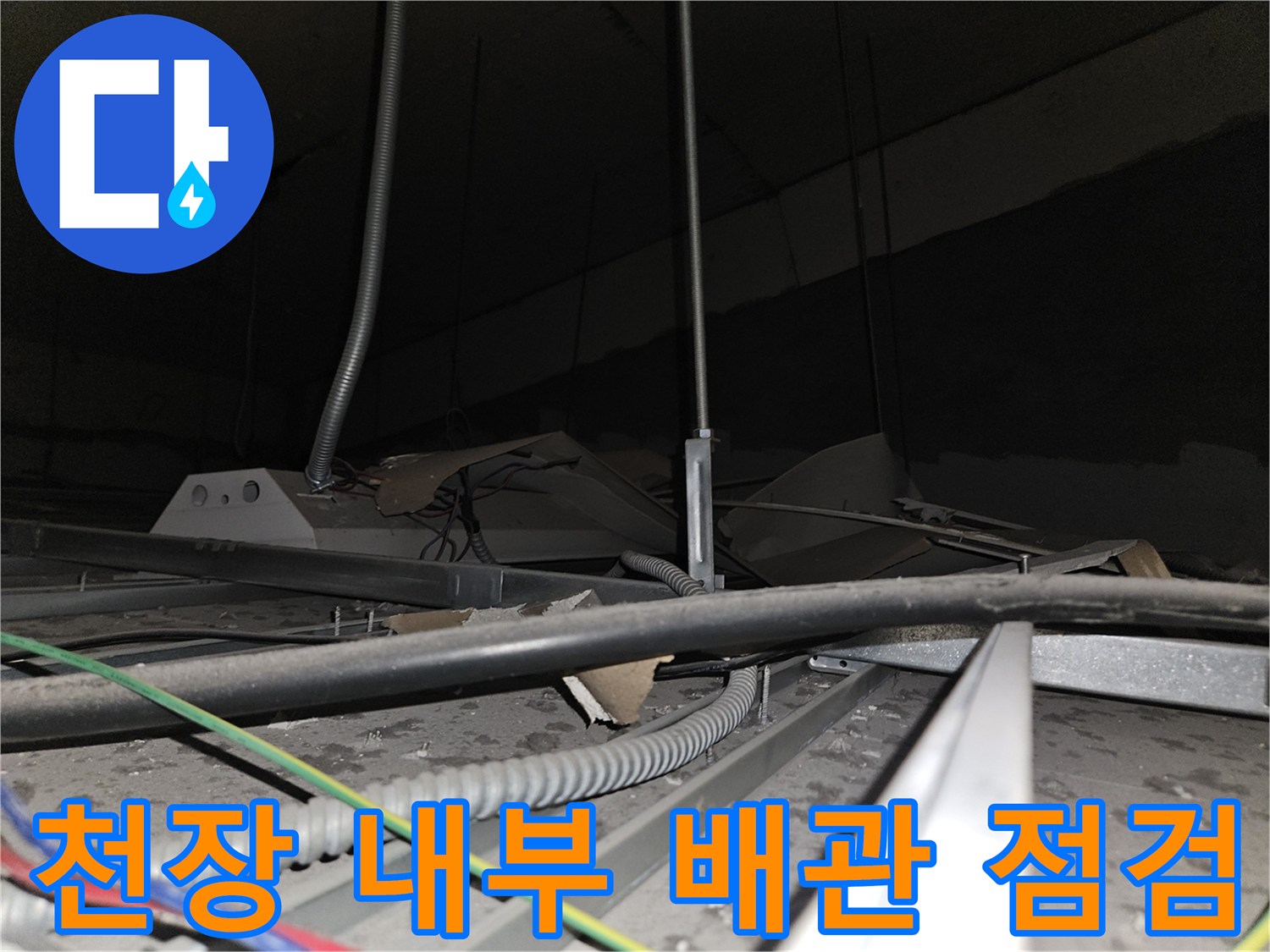 사무실 천장 텍스 사이로 보이는 금속 배관과 전선 상태