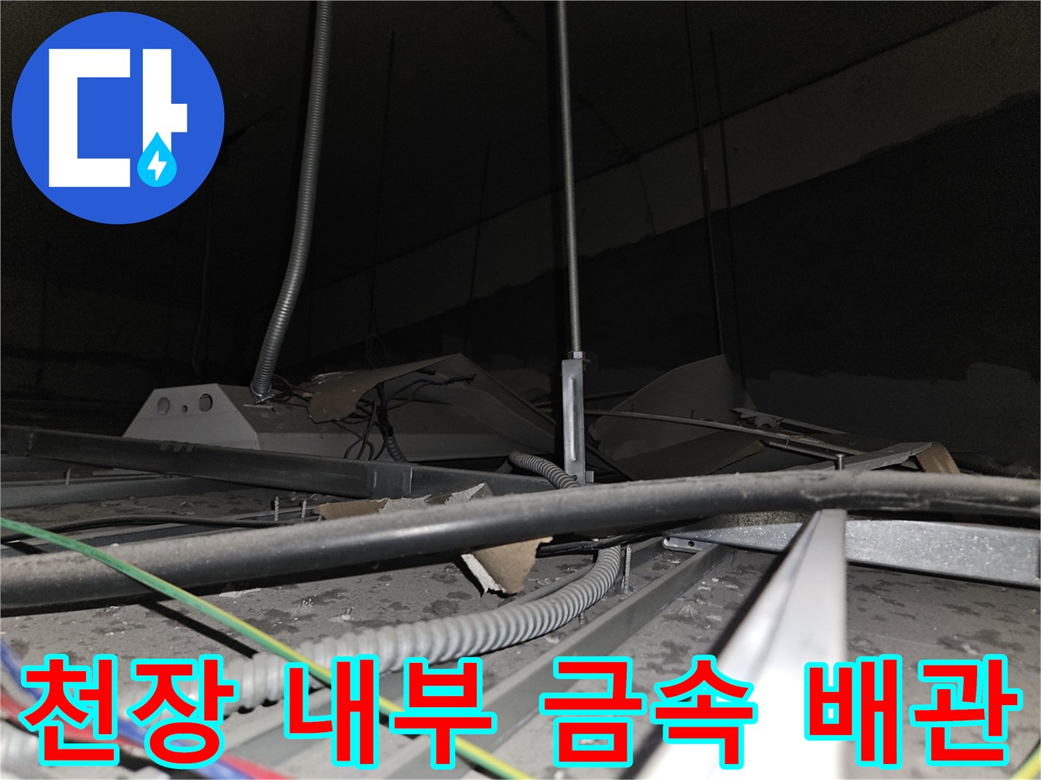 사무실 천장 틈새로 드러난 은색 주름관과 전선들