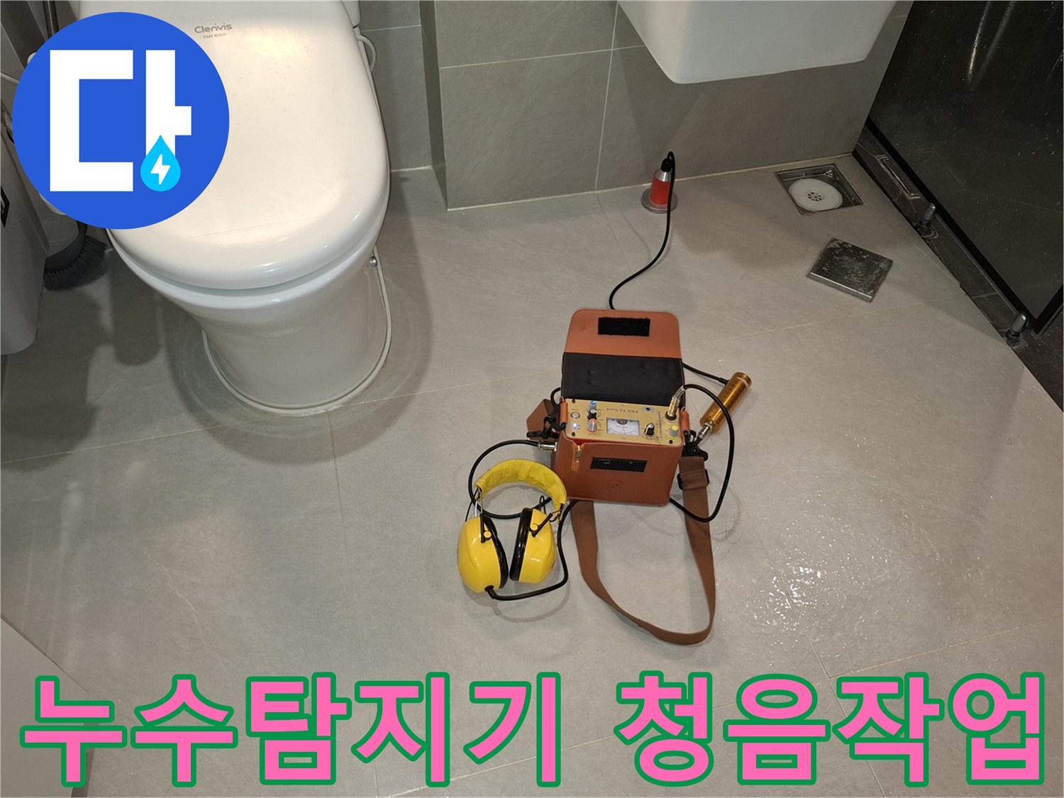 이 사진은-전문 엔지니어가-누수 지점을 파악하기 위해-청음 탐지 장비와-헤드폰을 사용하여-바닥의 미세한 소리를-듣고 있는 장면입니다