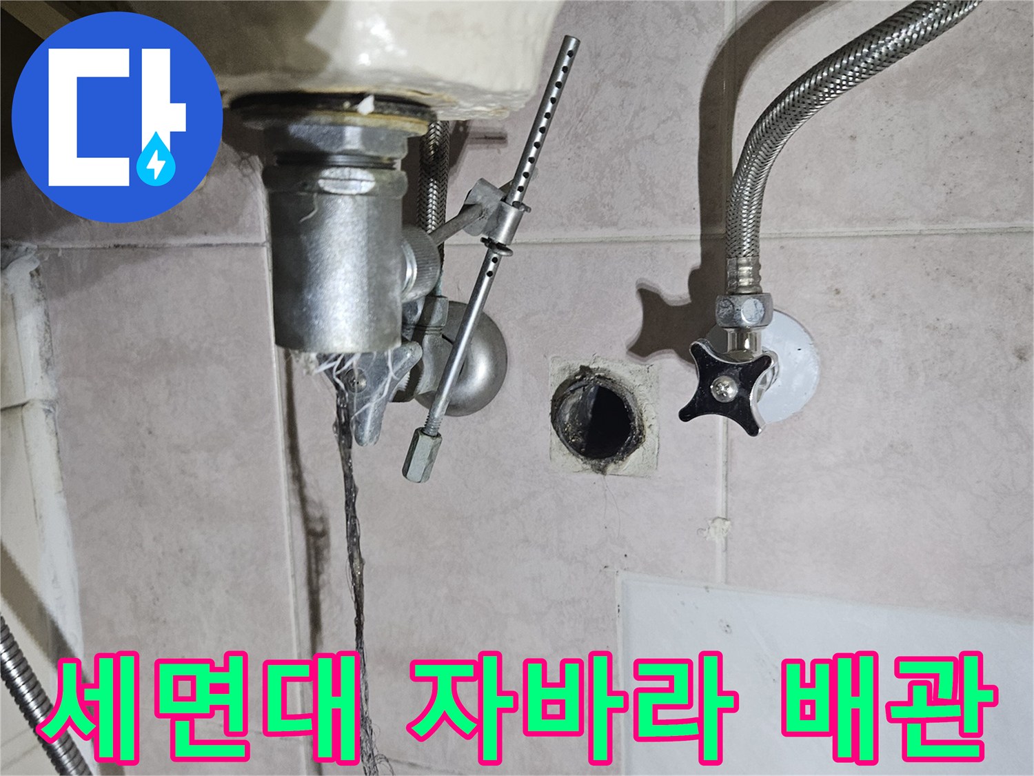 세면대 하단 앵글밸브와 연결된 은색 유연한 배관 모습