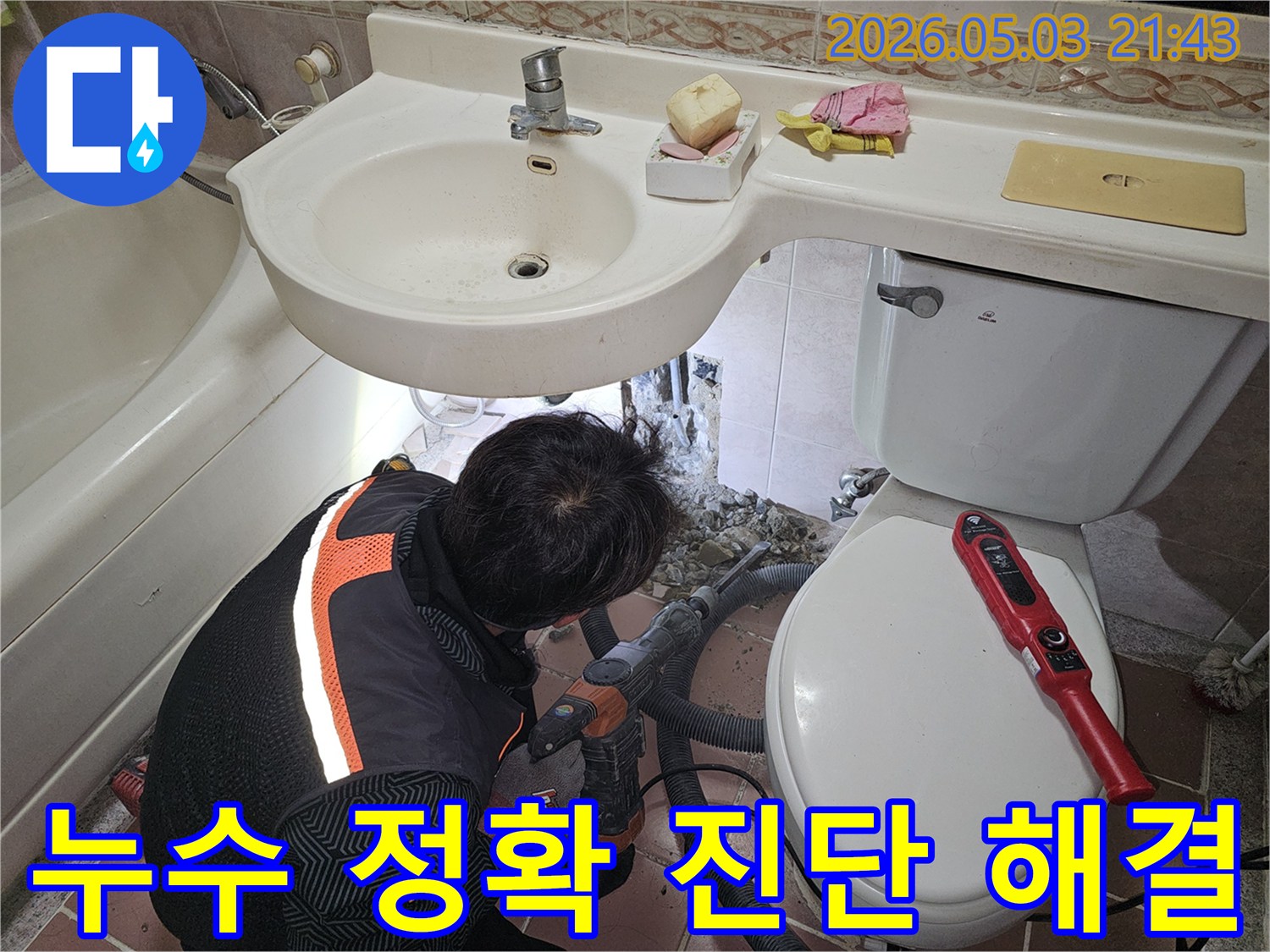 욕실 바닥에서 발생한 누수를-정확하게 진단하고 해결하기 위해-전문가가 파쇄 작업을 진행하는 현장입니다.