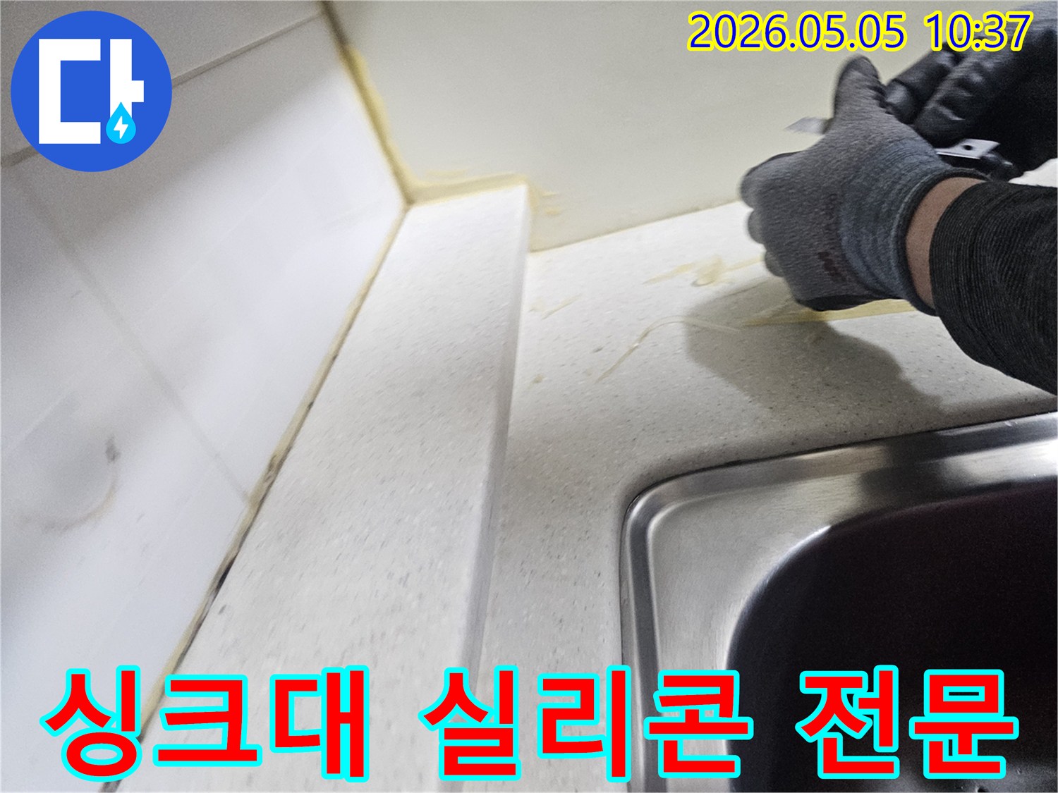 주방 싱크대 누수 해결을 위해-오래된 실리콘을 제거하는-전문가의 섬세하고 숙련된 작업