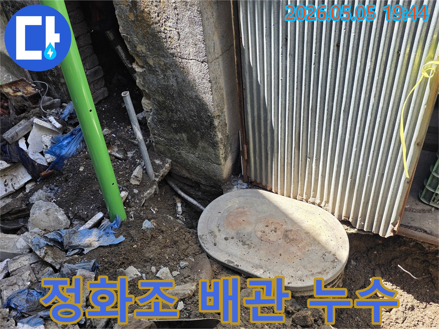 농가주택 주변에 설치된-정화조 배관에서-누수가 발생하여-전문가가 현장을-점검하고 있는 모습입니다.