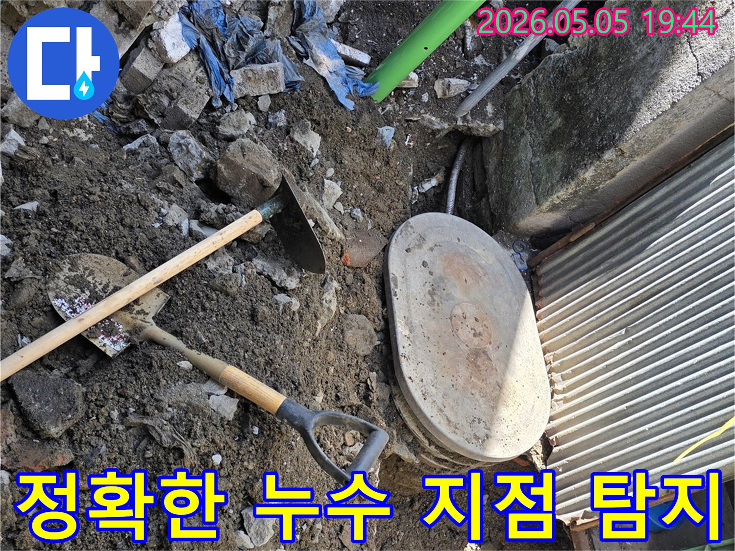누수 지점을 정확히 찾아내기 위해- 땅을 파내려간 현장으로- 흙과 파이프- 그리고 작업 도구들이 보입니다.