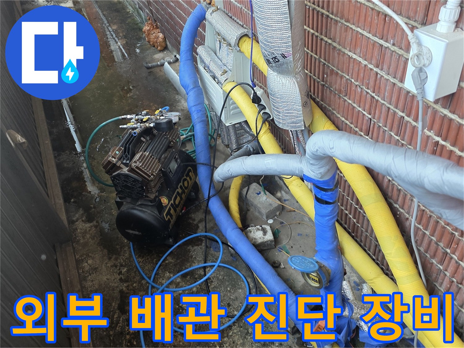 벽돌 벽면을 따라 설치된 노란색 및 파란색 배관과 압력 측정 장치