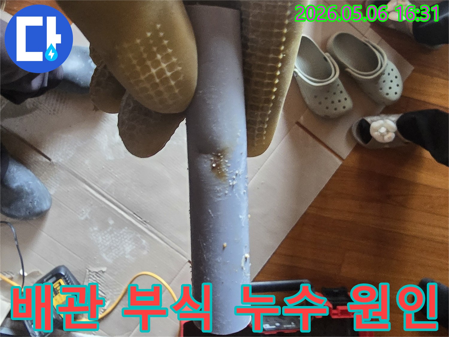 누수-엔지니어가-부식된-배관을-들고-누수-원인을-설명하며-교체-계획을-세우고-있습니다