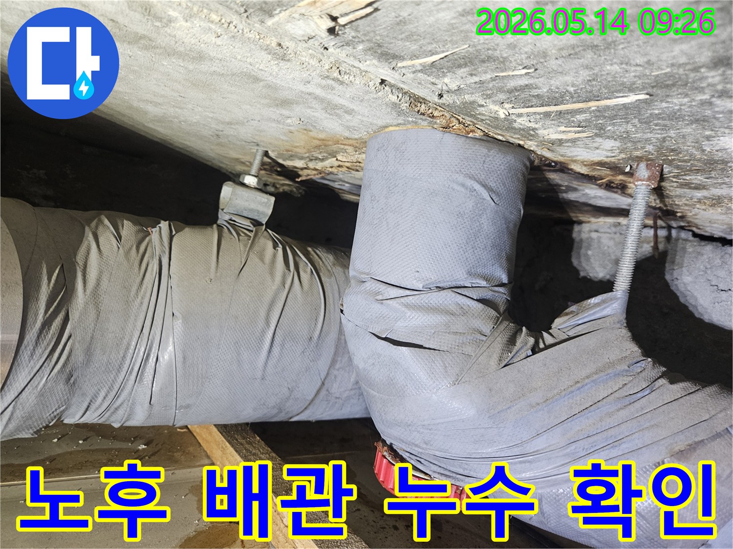 오래된 주택의 천장 배관에서-물이 새어 단열재가 손상된-누수 현장을 포착한 사진입니다