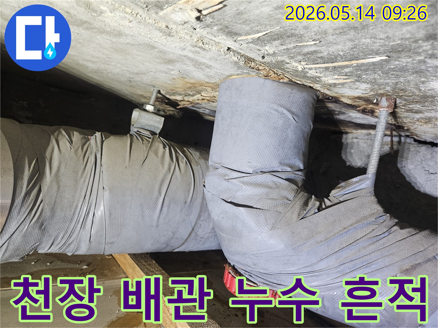 천장 아래 설치된 배관에서 물이 새어-단열재가 젖고 주변이 오염된-누수 현장을 보여줍니다