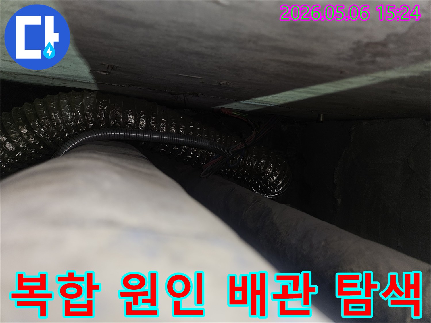 어두운-틈새에-숨겨진-복잡한-배관과-전선-사이에서-누수 원인을-정밀하게-탐색하는-과정을-보여주는-사진입니다