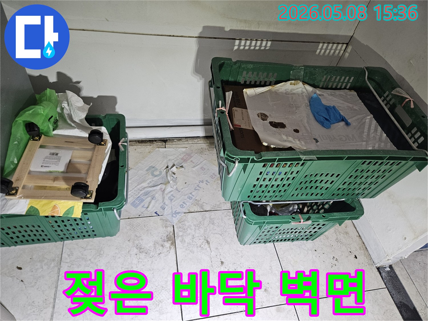 누수-엔지니어가-현장에서-젖은-바닥과-벽면의-물기를-제거하기-전-누수-상태를-정밀하게-기록하는-모습
