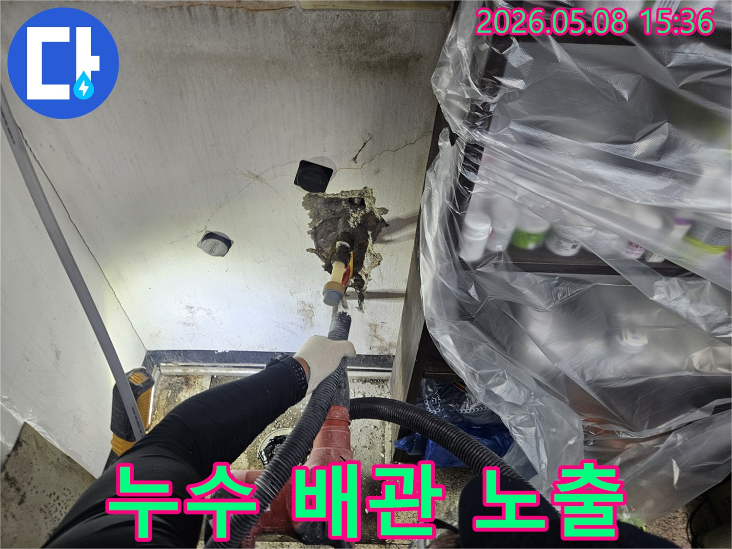 숙련된 엔지니어가-천안 목천읍의-누수 현장에서-천장을 파쇄하여-누수 원인 배관을-노출시키고-정확한 지점을-확인하는-모습입니다