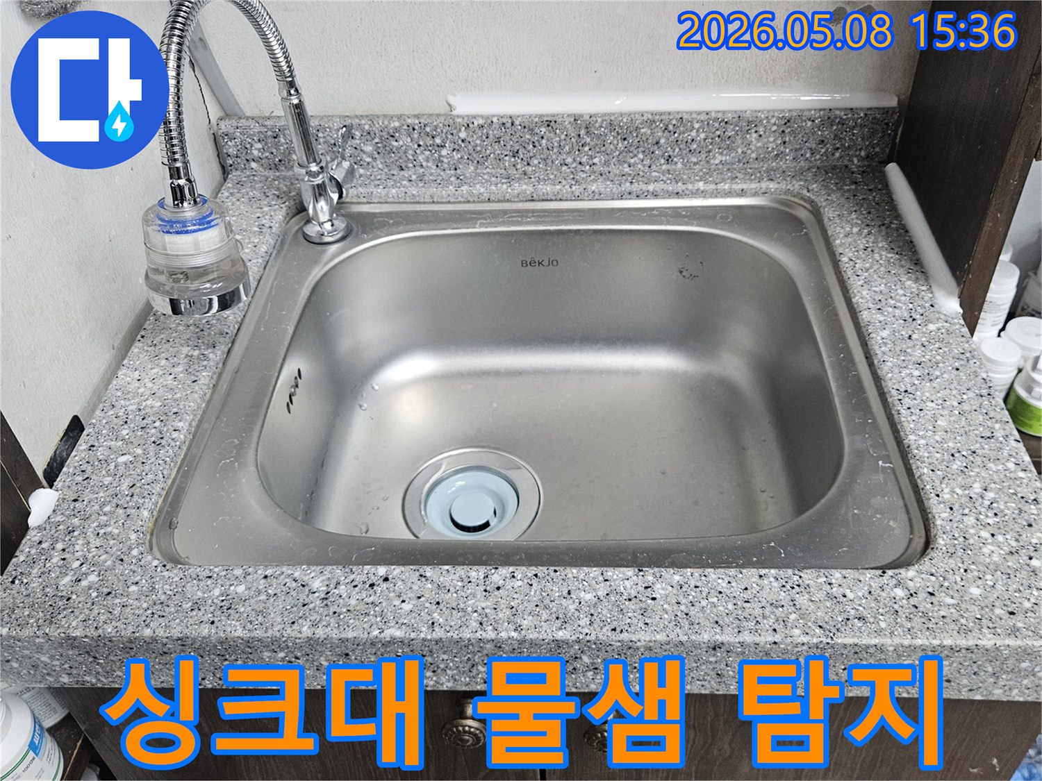 싱크대-수도꼭지-하단-정수-필터-연결부에서-발견된-누수-현장을-면밀히-살펴보는-장면