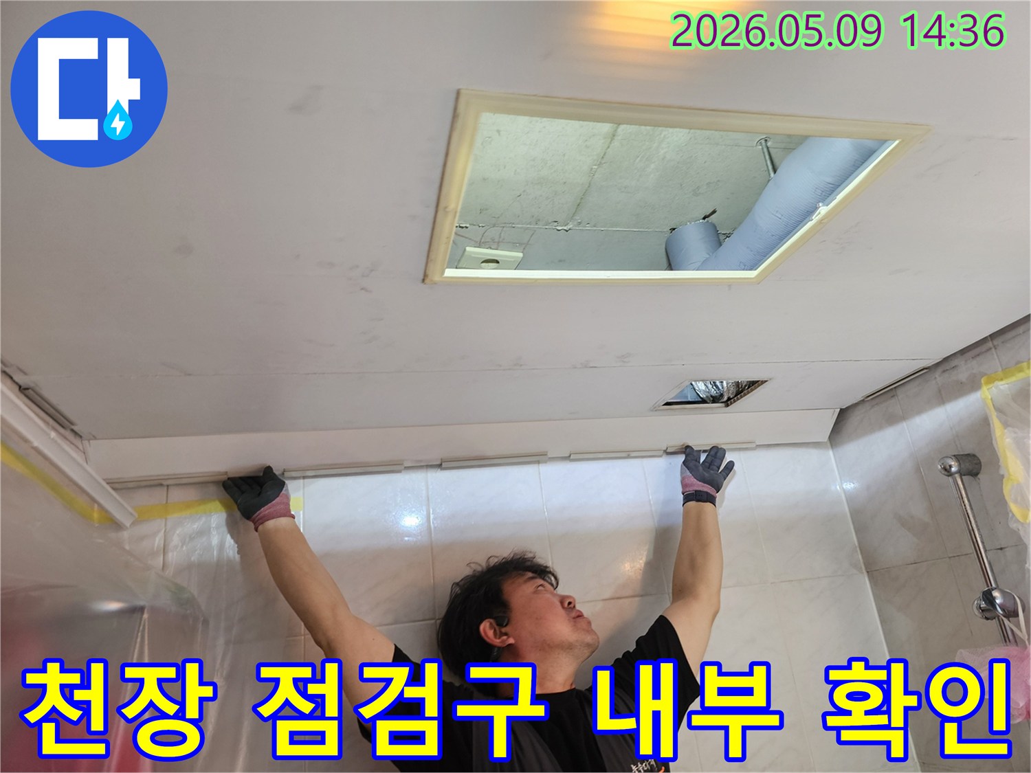 누수 엔지니어가 천장 점검구를 열고-내부 구조와 배관을-세밀하게 관찰하는-모습입니다.
