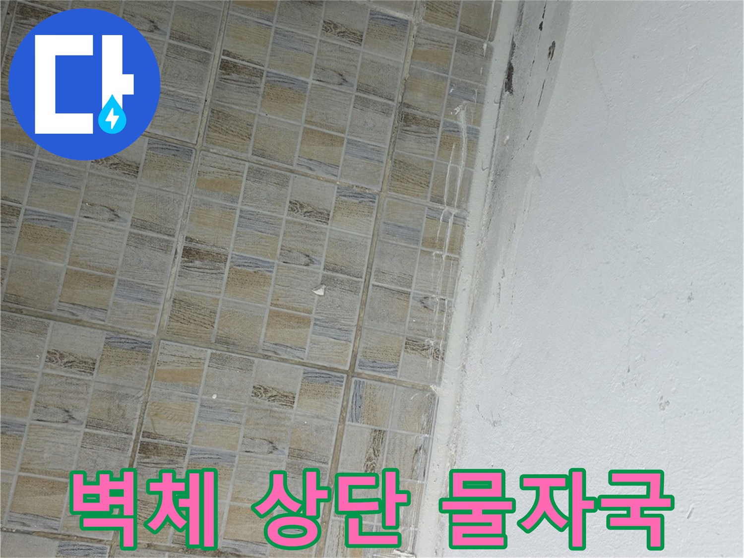 습기가 스며들어-변색된 타일 윗부분과 천장 경계의 누수 흔적
