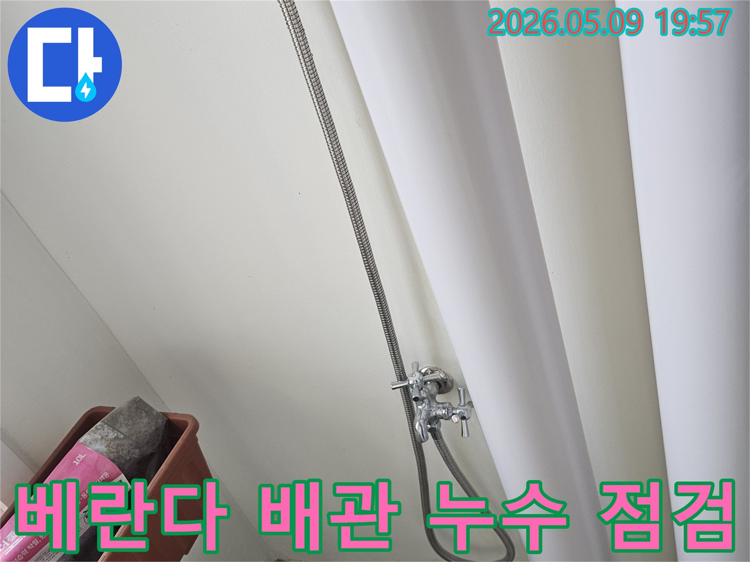 누수 전문 기술자가-베란다 내부의-배관 연결 부위를-꼼꼼하게 점검하며-누수 흔적을-찾아내는 현장입니다