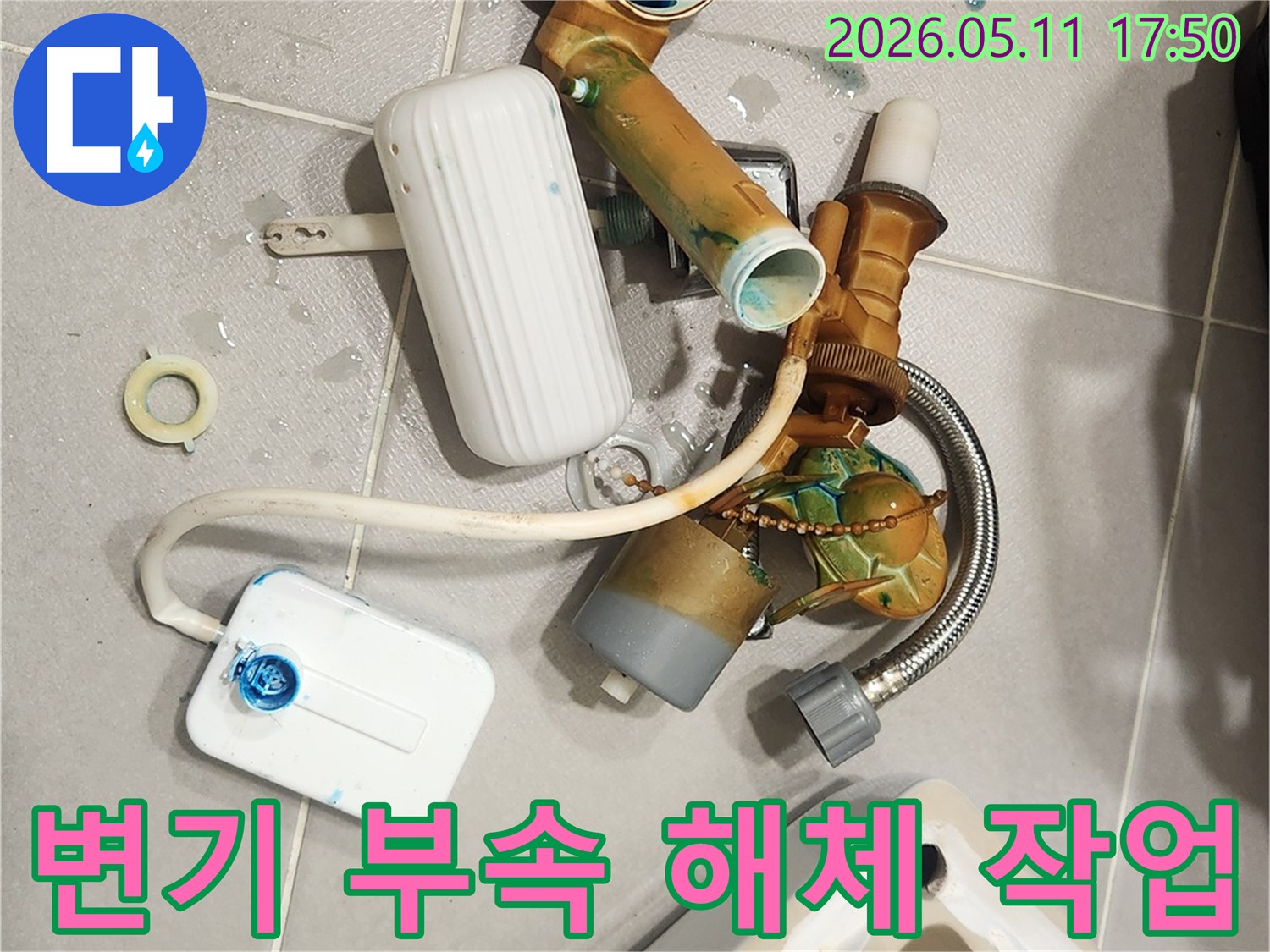 안방 변기에서 발생한 물샘 문제를 해결하기 위해-오래된 변기 부속들이 해체되어 바닥에 놓여 있는 모습입니다-새 부품으로 교체하여 변기를 수리할 예정입니다