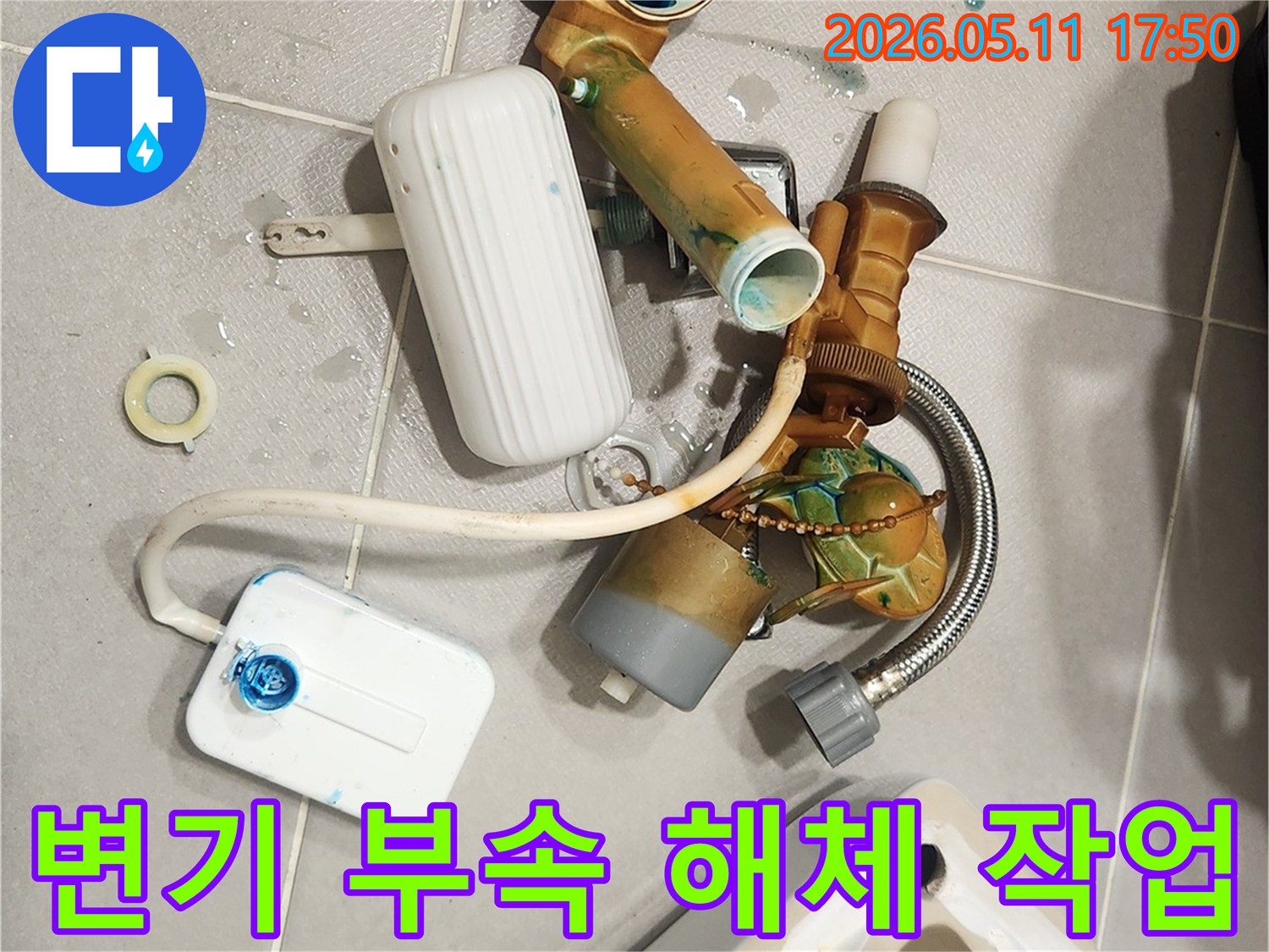 안방 변기에서 발생한 물샘 문제를 해결하기 위해-오래된 변기 부속들이 해체되어 바닥에 놓여 있는 모습입니다-새 부품으로 교체하여 변기를 수리할 예정입니다
