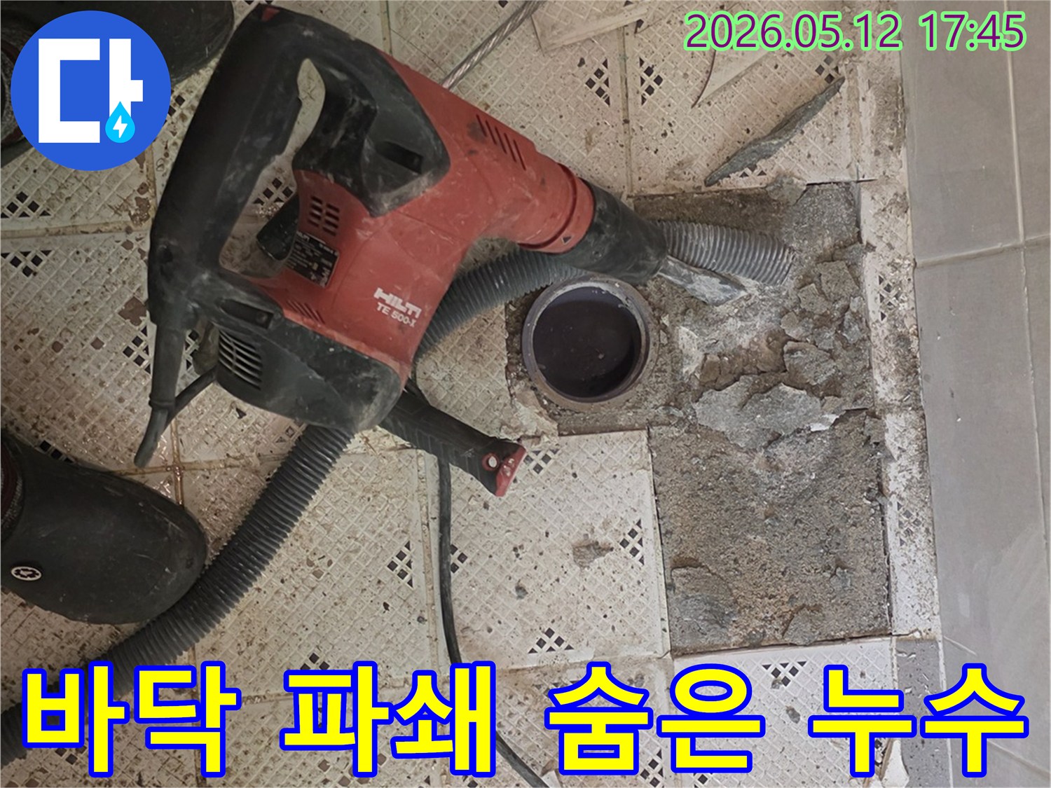 숨겨진 누수를 찾기 위해-바닥 타일을 파쇄하는-전문 장비와-작업자의 발이 보이는-작업 현장입니다.