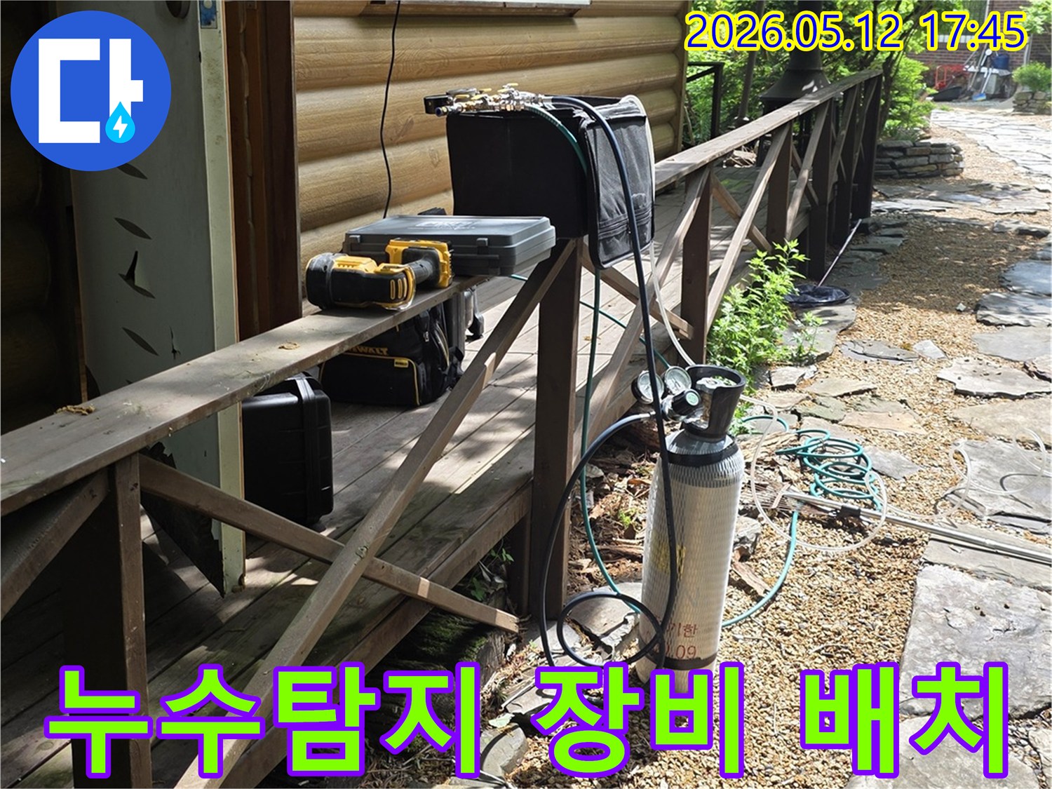 주택 옆 경사면에-누수 탐지용 가스통과-각종 공구들이-안전하게 놓여 있습니다