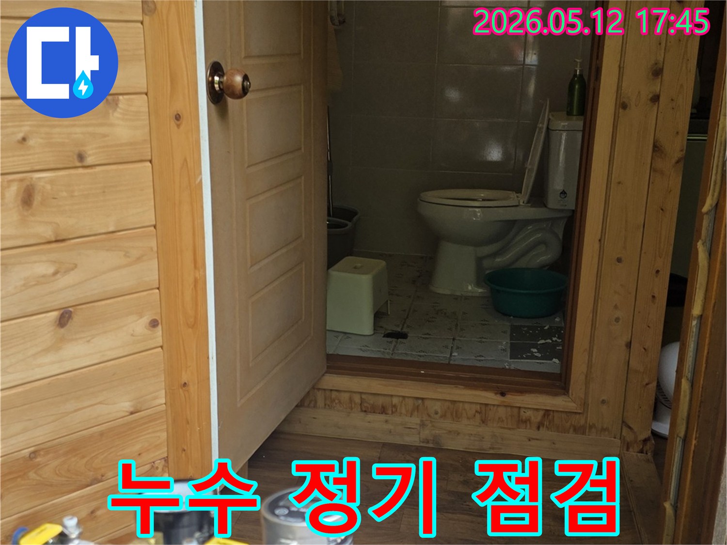 화장실 문 앞에서-누수 탐지 장비가-정기 점검을 위해-정밀하게-작동 중인 모습