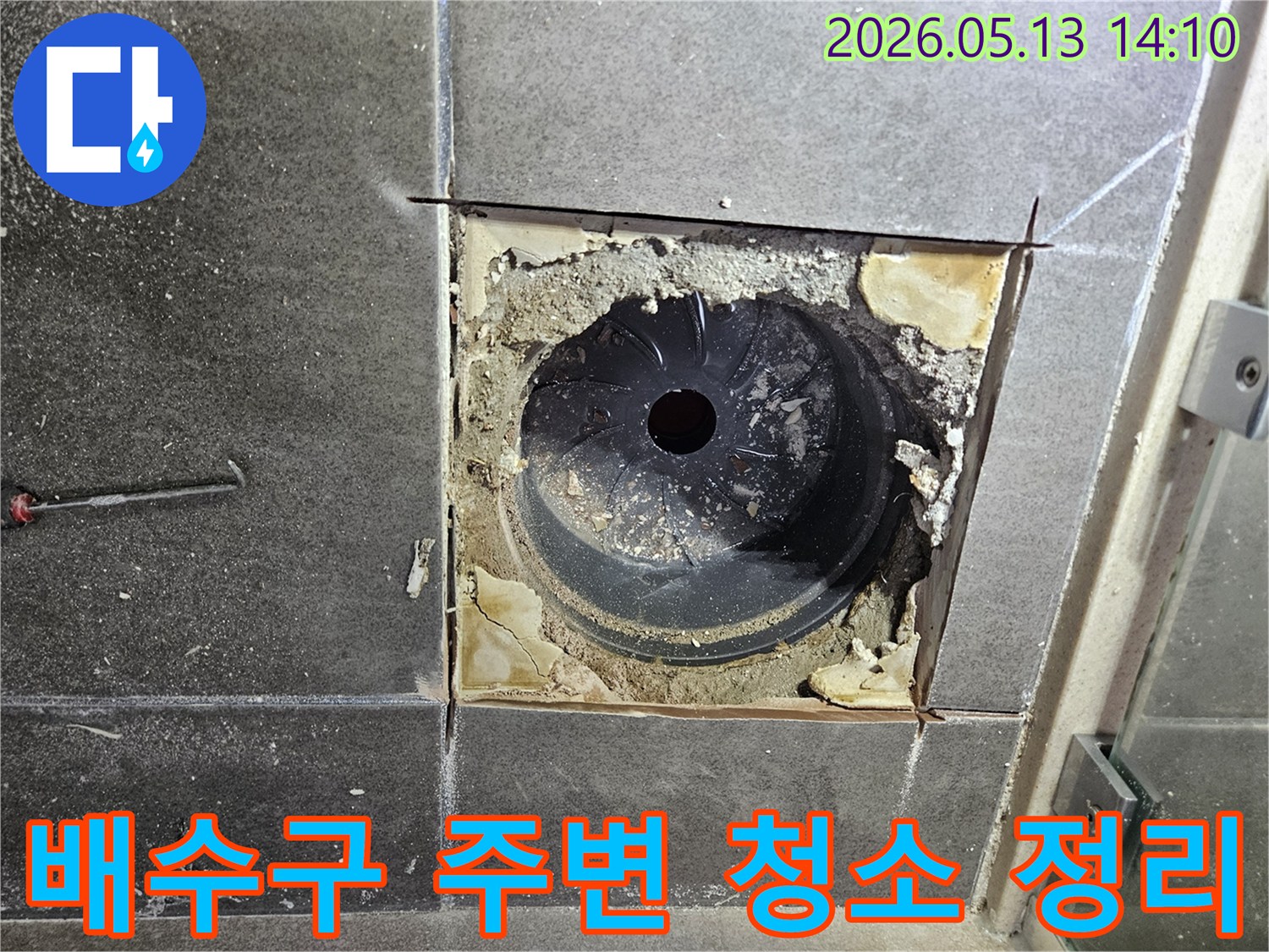 욕실 바닥 누수 공사를 시작하기 전-배수구 주변의 이물질을 깨끗하게 청소하고-작업 환경을 정리하는 모습입니다