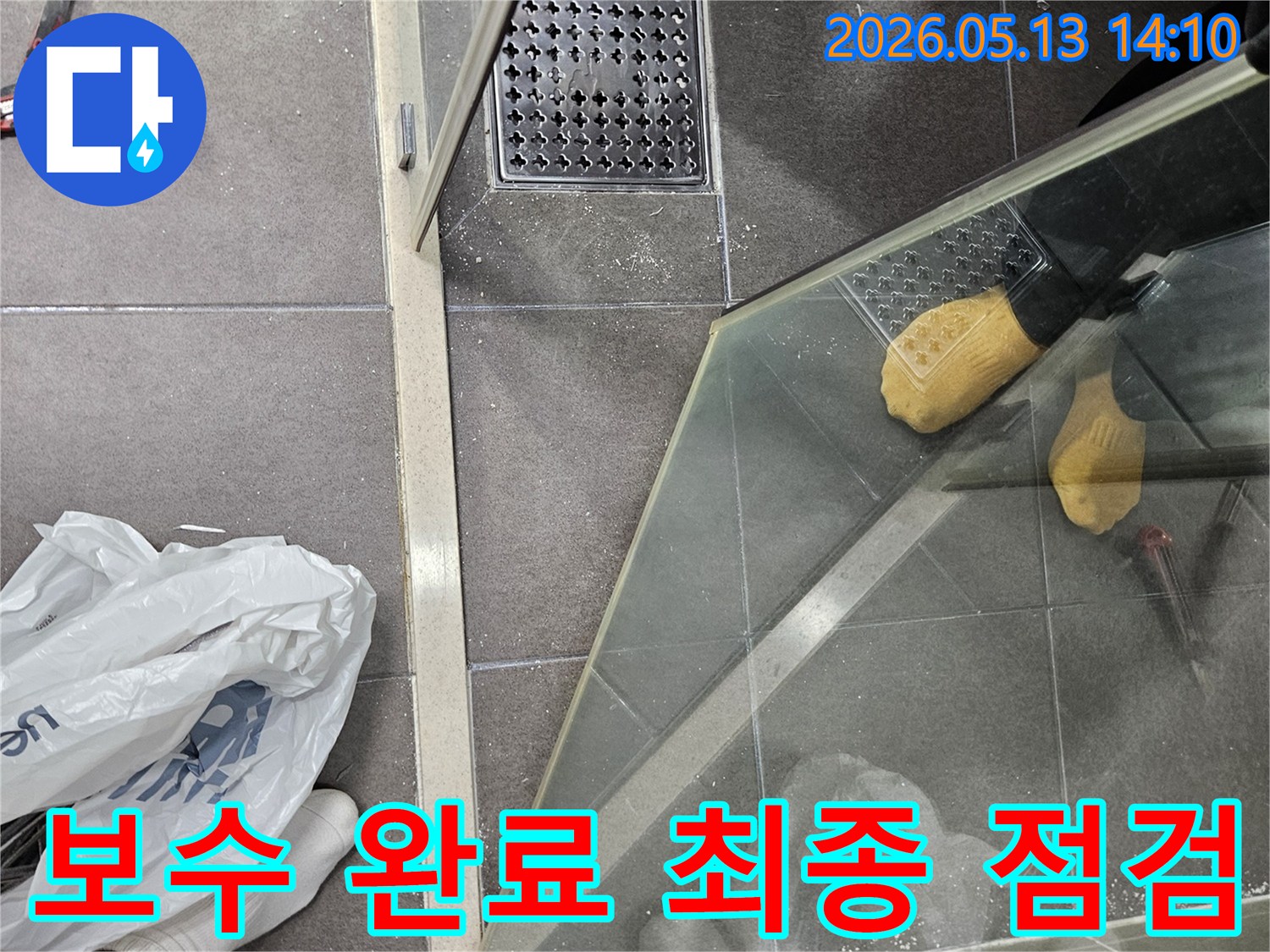 욕실 샤워 부스 하단부와 배수구 주변의-누수 보수 작업이 완료된 후-최종 점검을 준비하는 현장입니다.