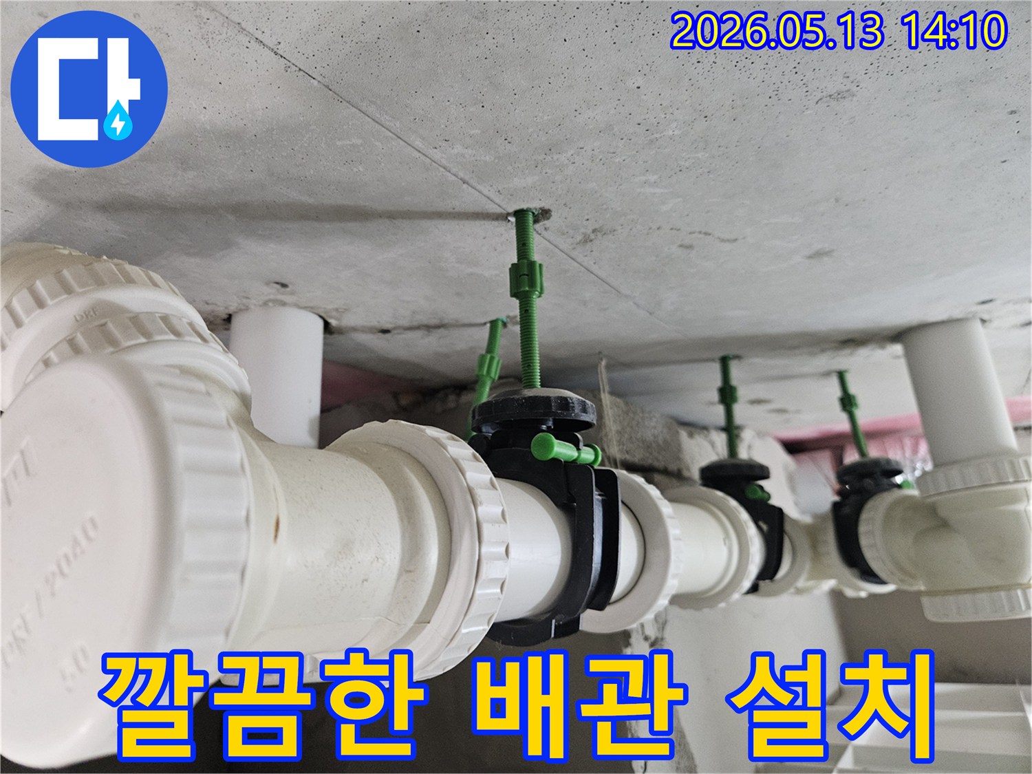 콘크리트 천장 아래에 일렬로 정돈된 흰색 배관과-검은색 밸브들이 가지런히 설치된 모습