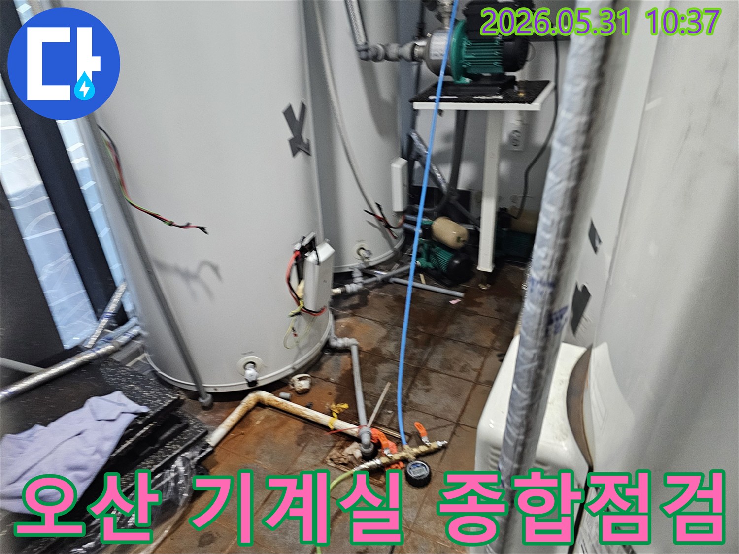 이 이미지는-오산-지역의-기계실에서-전문가가-다양한-배관의-누수-여부를-종합적으로-점검하고-있는-현장-모습을-보여줍니다.
