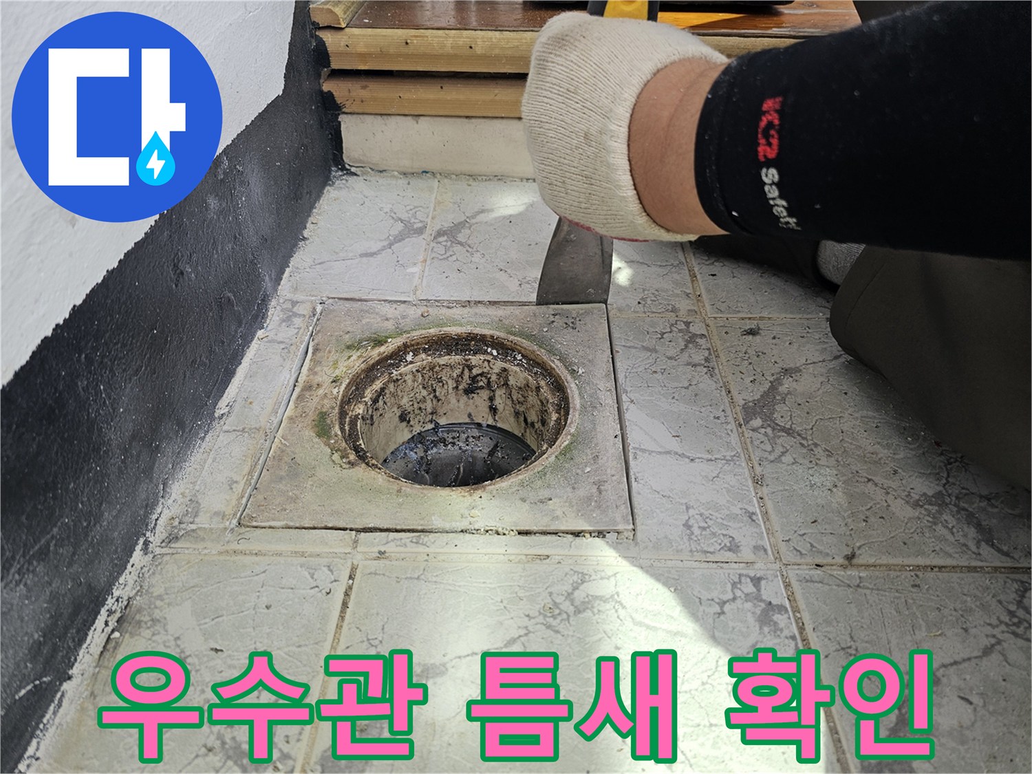 우수관 배관 주변 타일 사이의 누수 흔적을 근접 촬영함