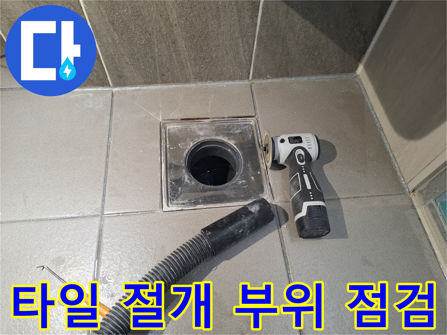 화장실 배수구 주변 타일을 제거하여 내부 배관을 노출시킨 상태