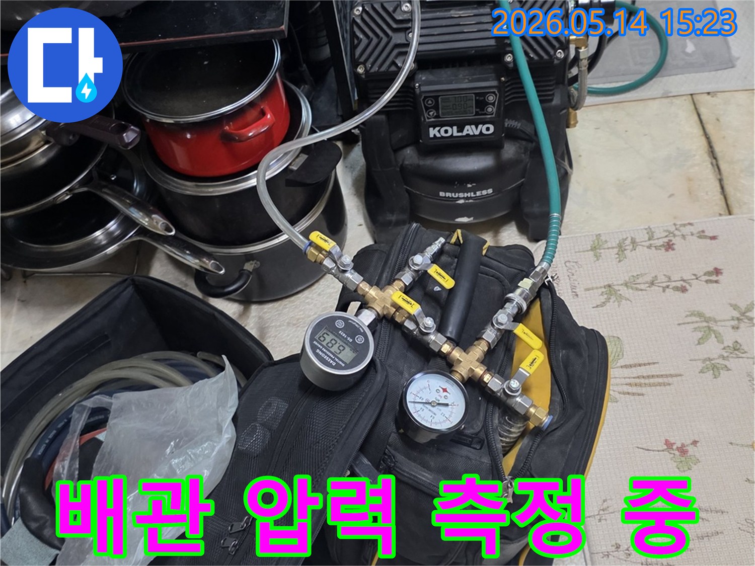 누수 탐지를 위해 배관에 연결된 압력 테스트 장비가 작동 중인 모습