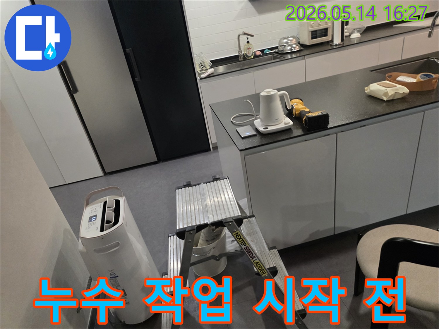 누수 탐지 전문가가-고객님의 주방에서-작업 전-장비 점검과-환경 확인을 하고 있습니다.