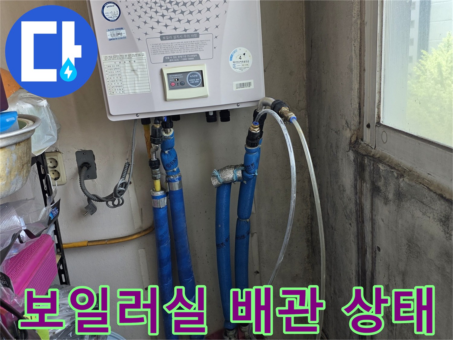 보일러 하단에 연결된 파란색 배관과 보일러 본체 모습