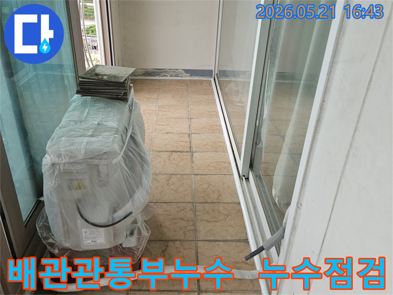 신북면-아파트-베란다의-에어컨-실외기-배관이-벽면을-관통하는-부위에서-누수-여부를-점검하는-모습