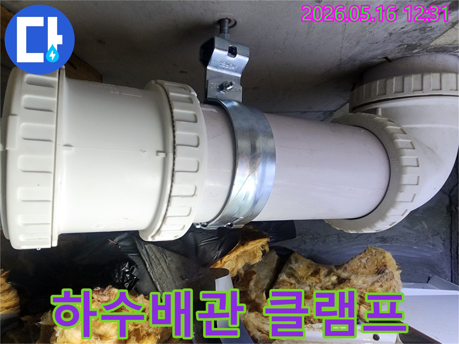 천장 콘크리트에 고정된 하수배관과-이를 지지하는 금속 클램프의 견고한 설치 상태입니다.