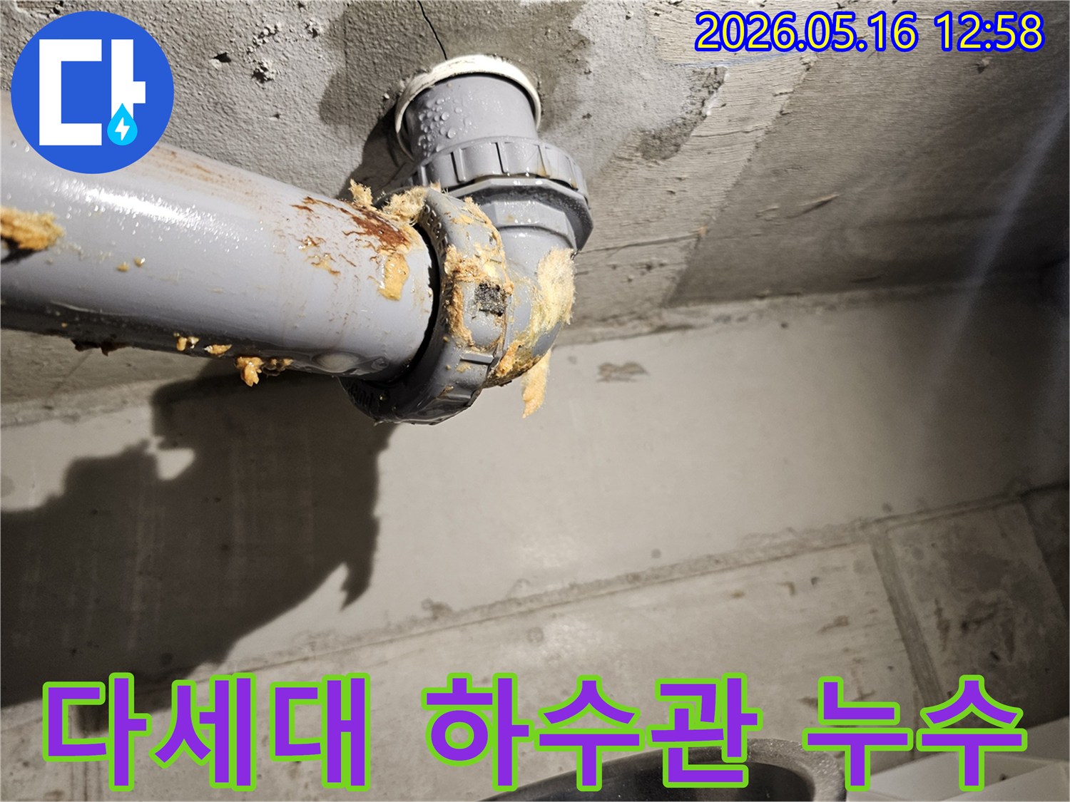 다세대-주택-천장-아래-하수관-연결부에서-물이-새어-나와-단열재가-젖은-모습을-보여주는-누수-현장-사진