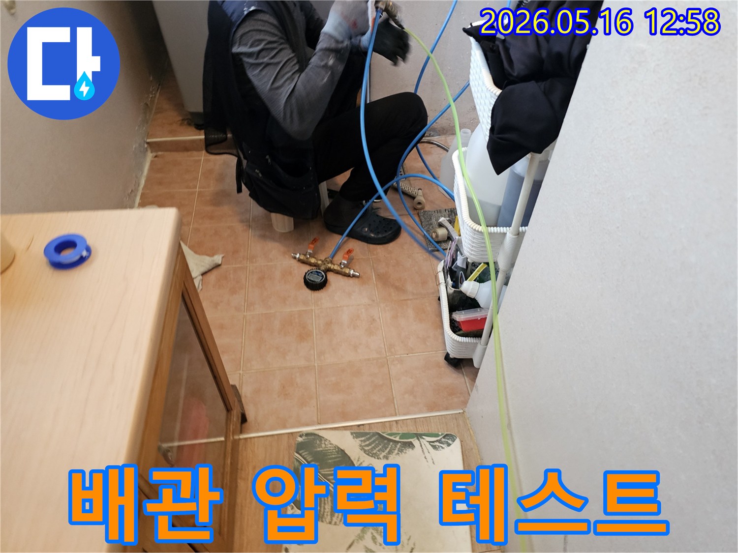 숙련된-기술자가-수도배관-누수-여부를-확인하기-위해-정밀-장비를-연결하고-있는-현장-사진