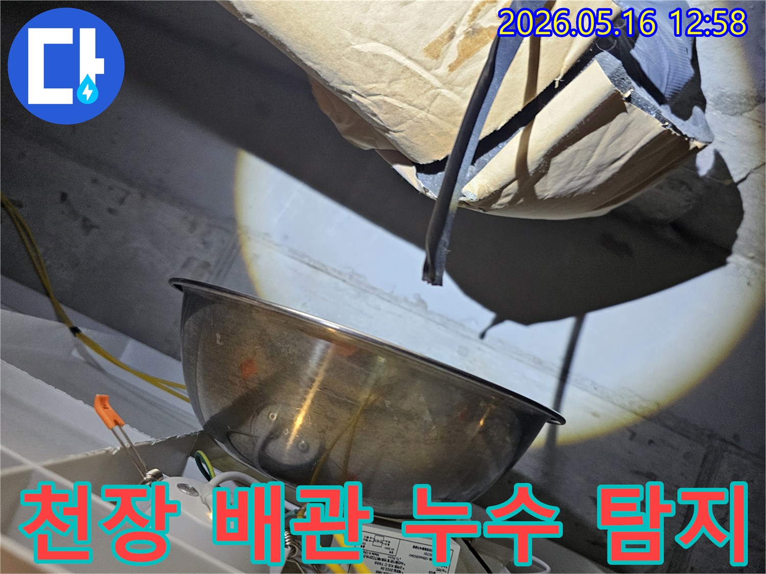 어두운 천장 아래에서-밝은 조명으로-배관의 누수 지점을-정확히 탐지하는-전문가의 모습입니다