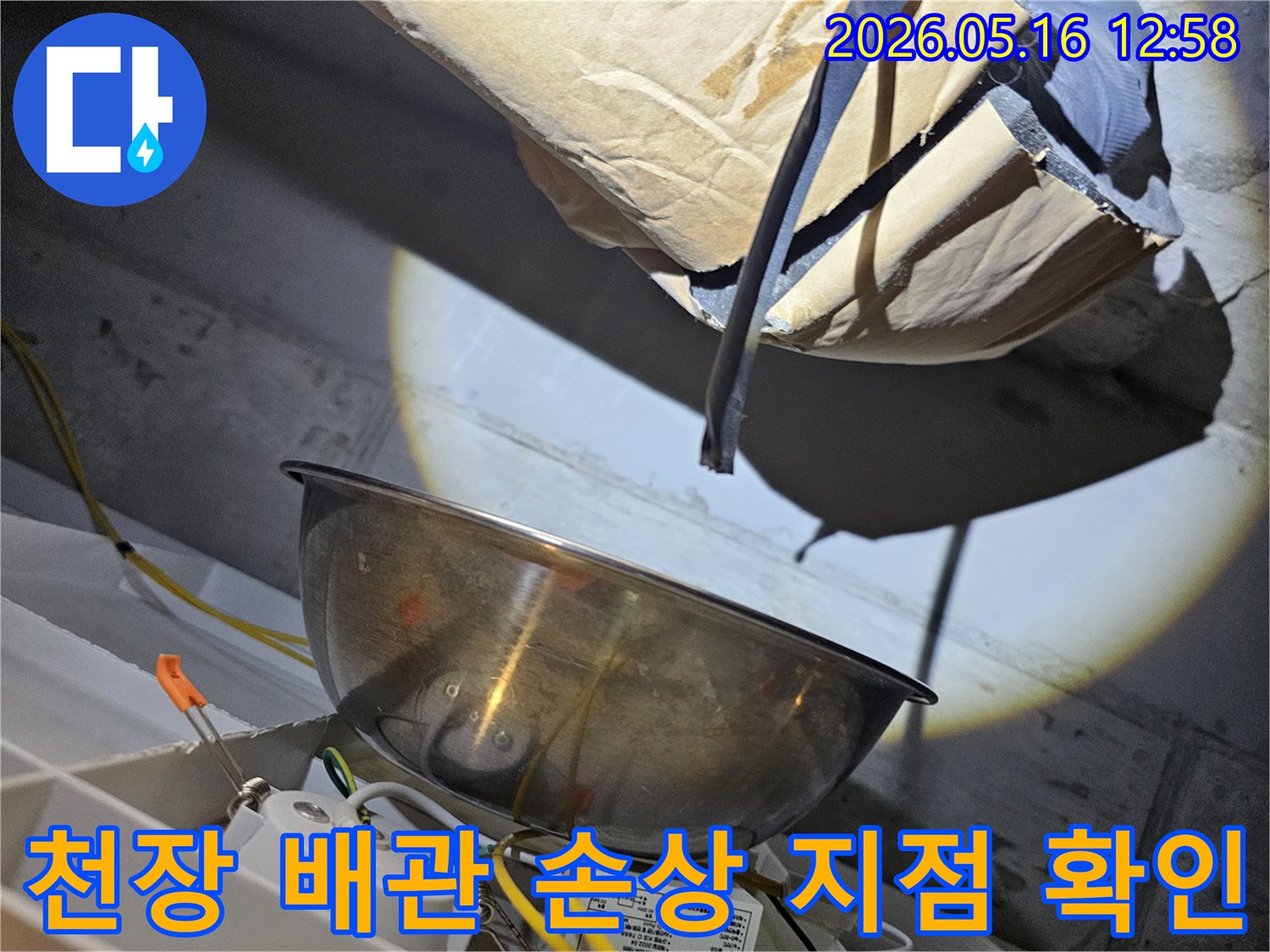 천장 속 어두운 공간에서-밝은 조명으로-배관의 손상 지점을-육안으로 꼼꼼히-확인하는 모습입니다