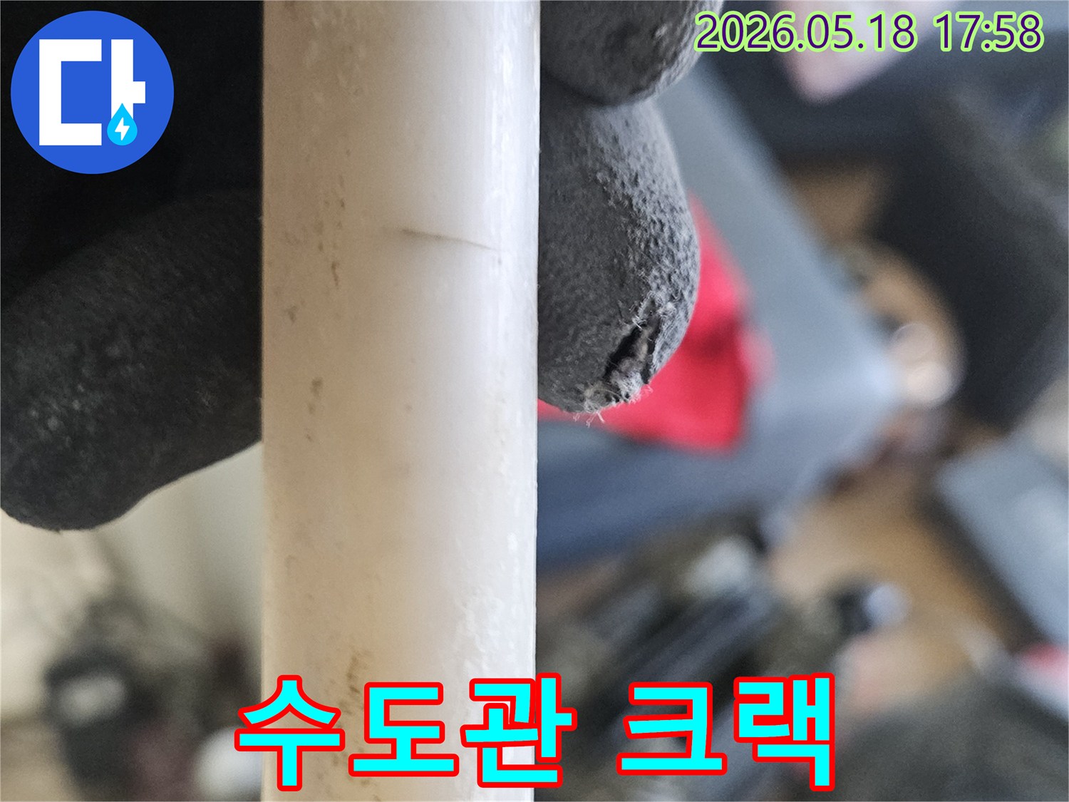 작업용-장갑을-낀-손으로-파손된-배관의-누수-지점을-가리키는-현장-이미지