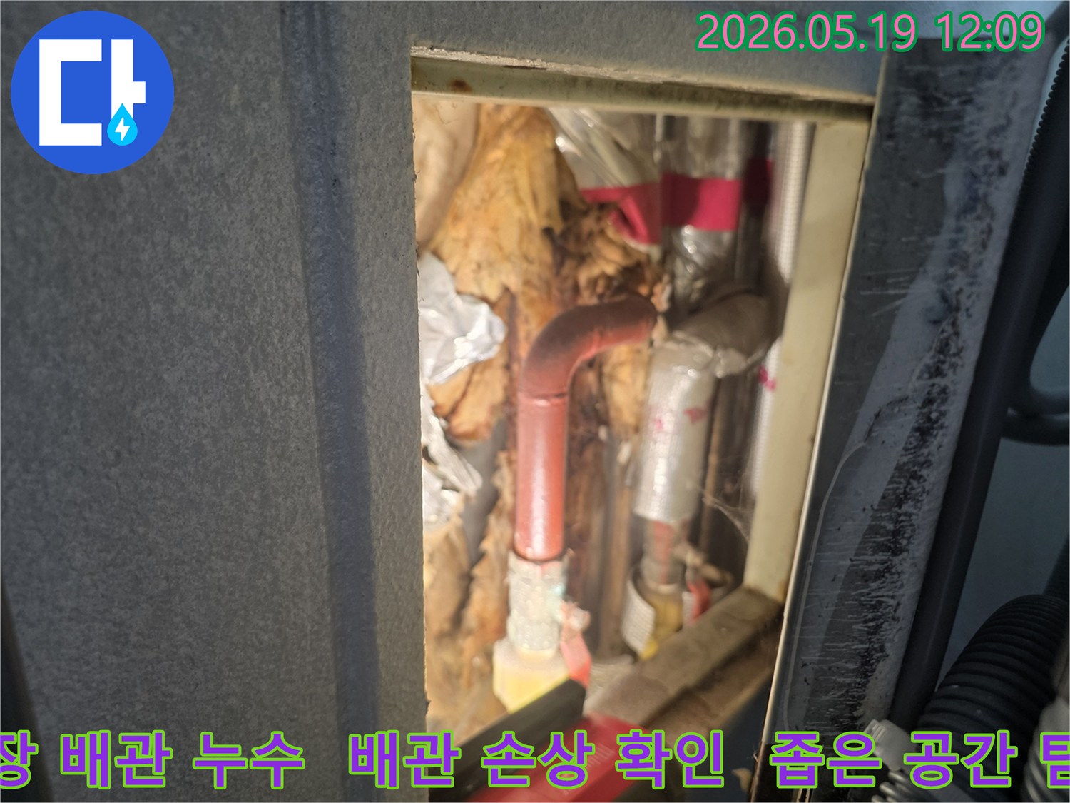 천장 속 좁은 공간에 위치한-손상된 배관과 젖은 단열재를 점검하는 전문가의 모습