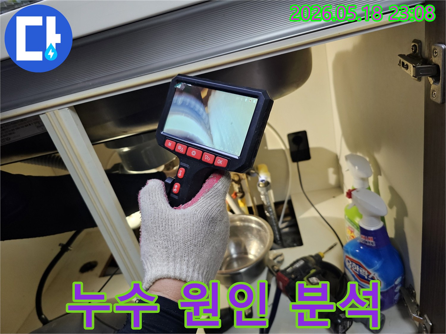 싱크대 하부-좁고 어두운 공간에서-누수 원인을 파악하기 위해-내시경을 사용하는 모습