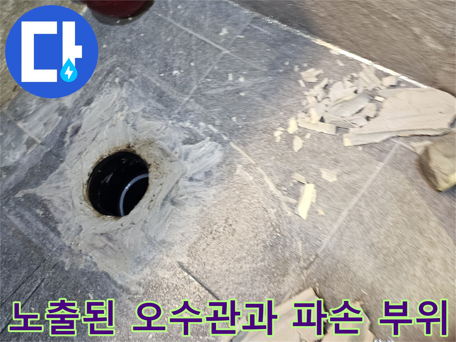 변기를 들어낸 후-드러난 배관 입구와 주변의 깨진 타일들