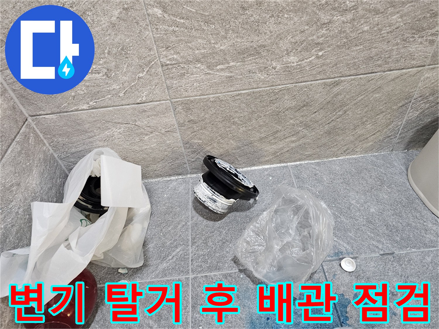 탈거된 변기 주변의 젖은 타일과 교체용 부속품