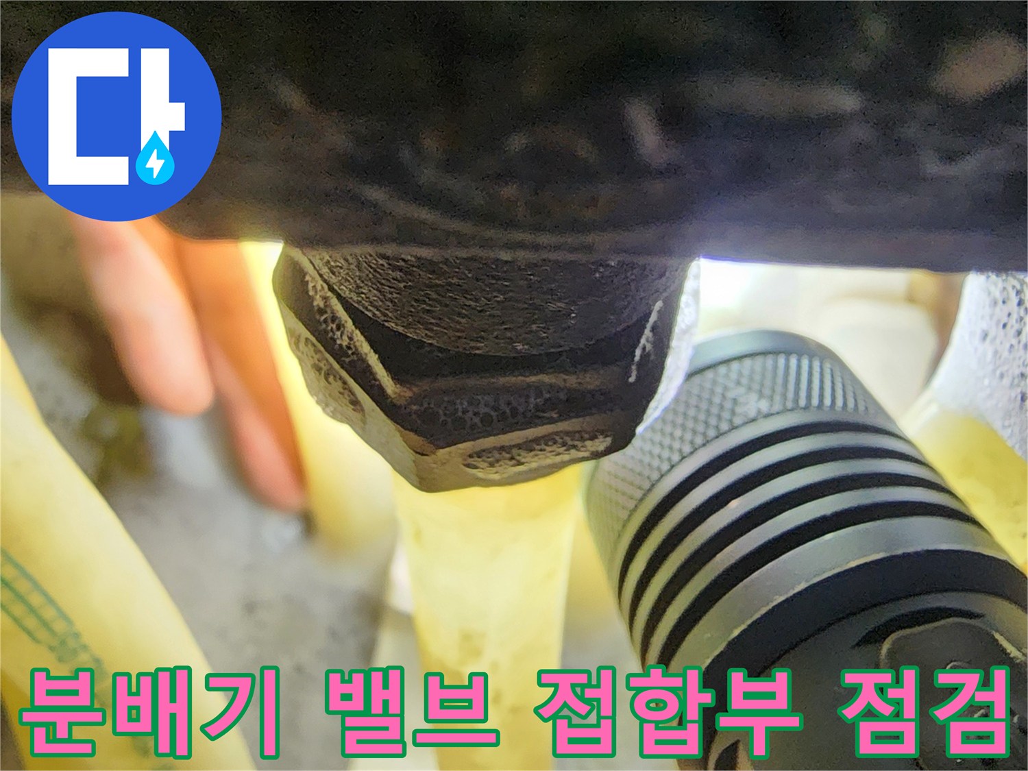 손전등으로 조사 중인-싱크대 하단 분배기 금속 부품